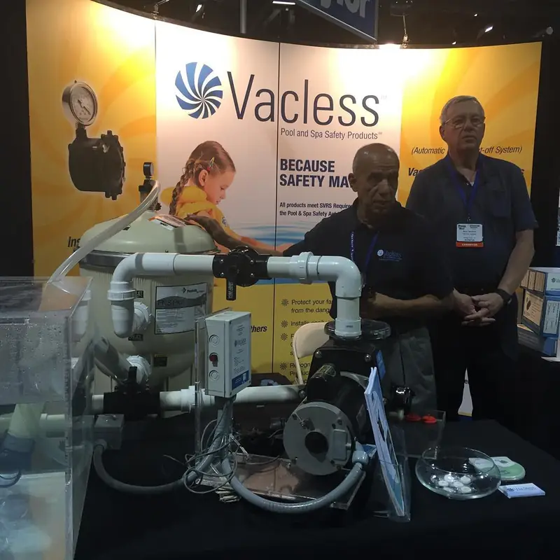 The Vacless trade show booth with its logo backdrop and a working demonstration rig